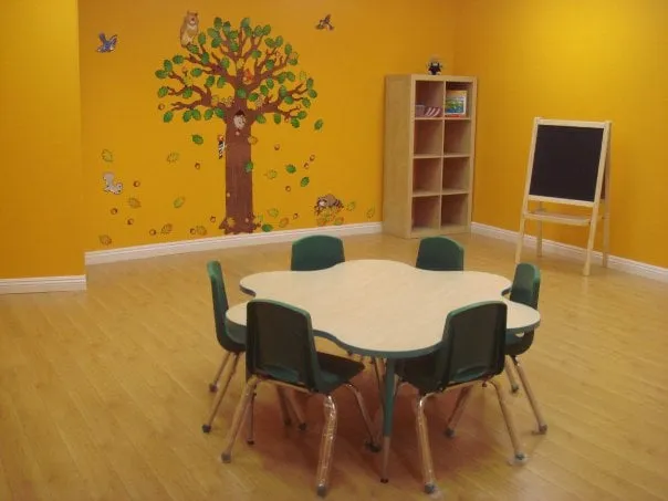 Kids Planet Glendale classroom with a tree mural and activity table