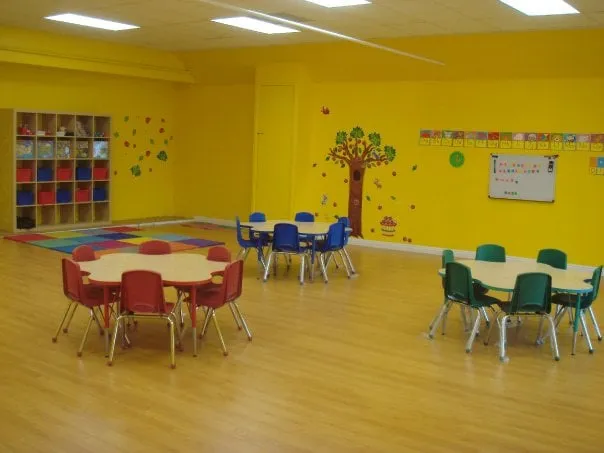 Bright yellow classroom at Kids Planet Glendale with child-sized tables and chairs